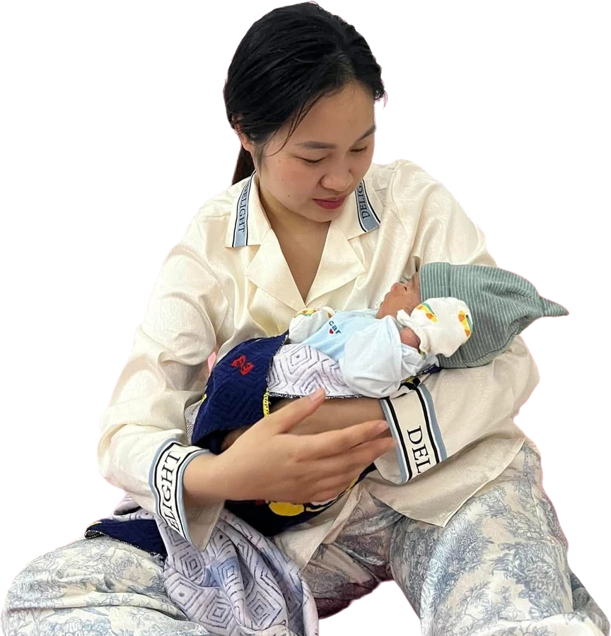 A mother holding her swaddled newborn