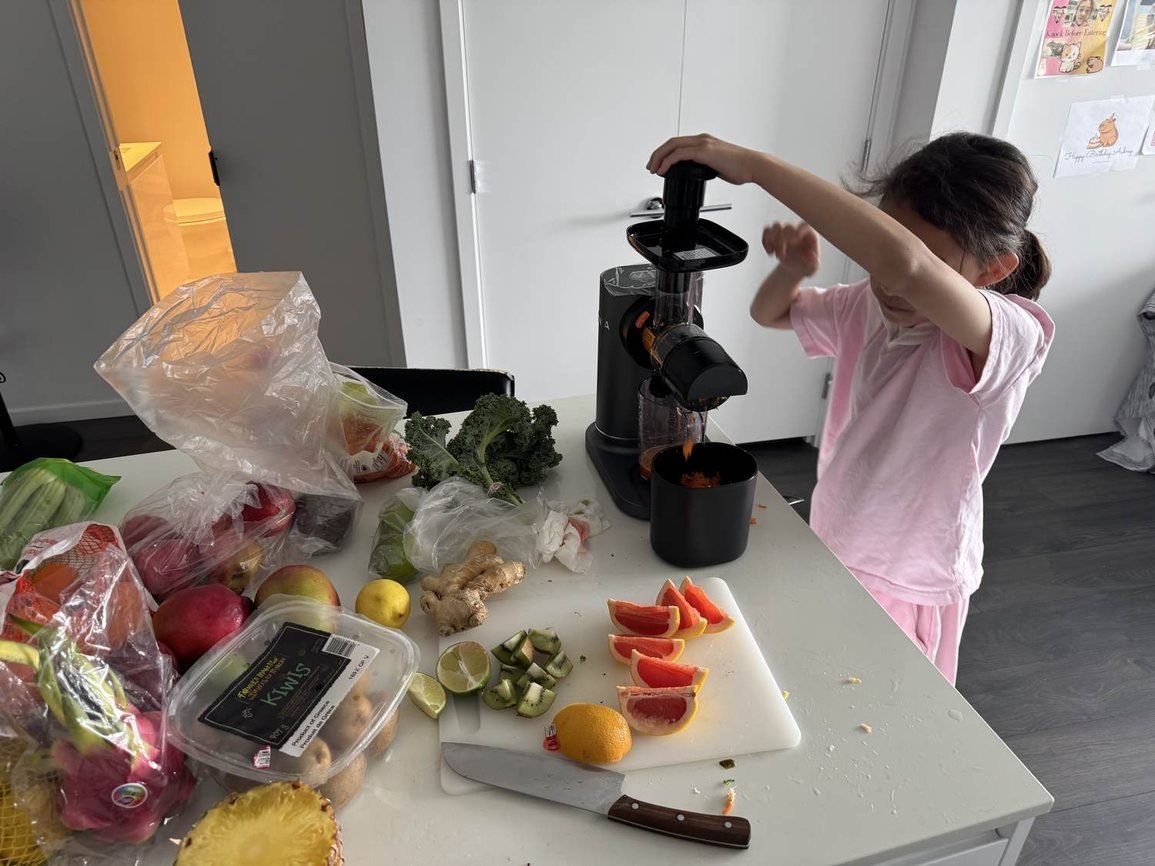 A young client pressing fresh fruit through the juicer